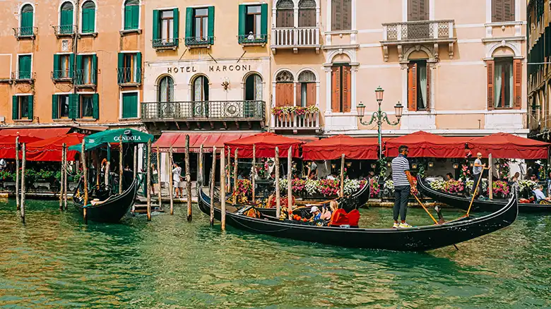 Hotel Metropole facade in Venice with green shutters and ornate street lamps