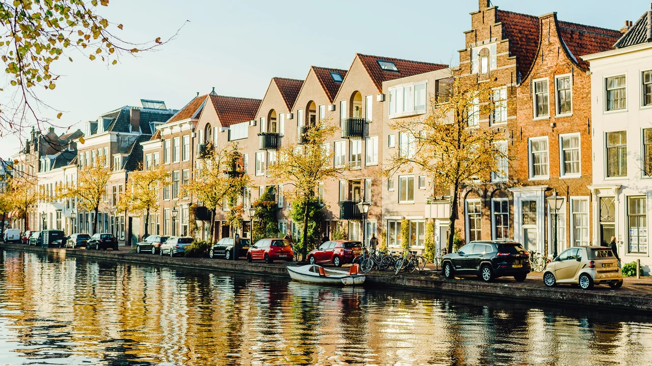 Historic Amsterdam canal houses and autumn trees reflected in the water
