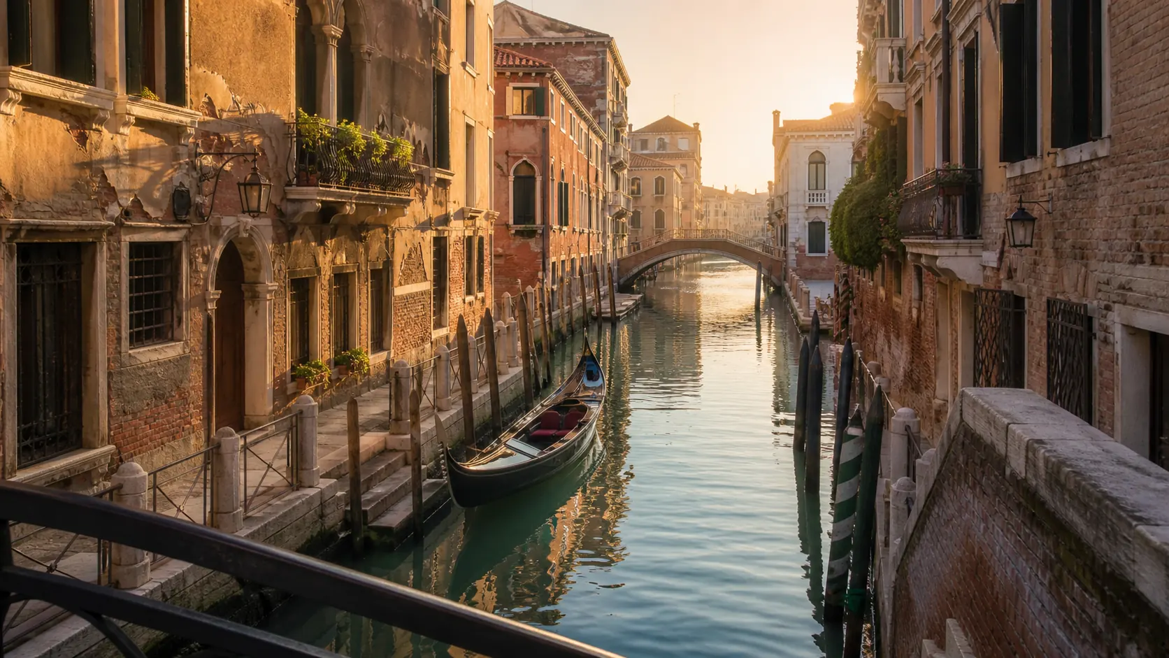 Quiet Venice canal and gondola in warm morning light