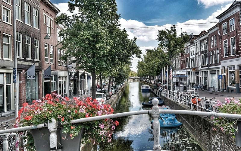 Weekend breaks in Amsterdam - a canal with boats and buildings and trees