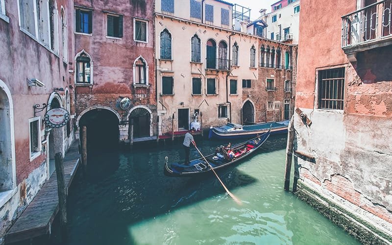 a gondola on a canal with buildings in the background