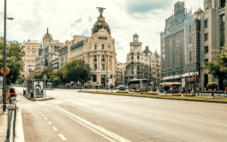 a street with a large building and a statue on top