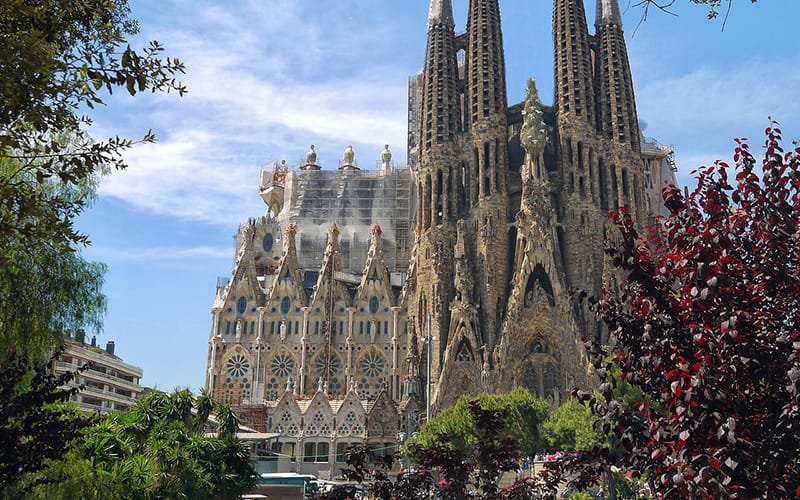 a large building with towers with Sagrada Família in the background