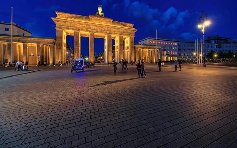 short breaks in Berlin - a large stone building with columns and people walking around