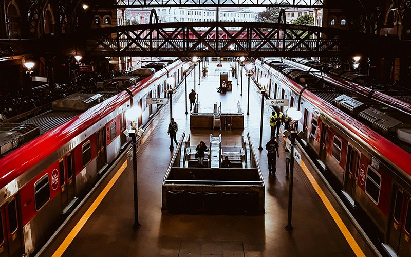 a train station with people standing in front of them