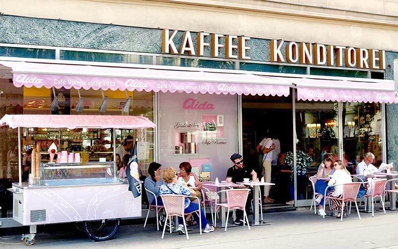 a group of people sitting outside a cafe