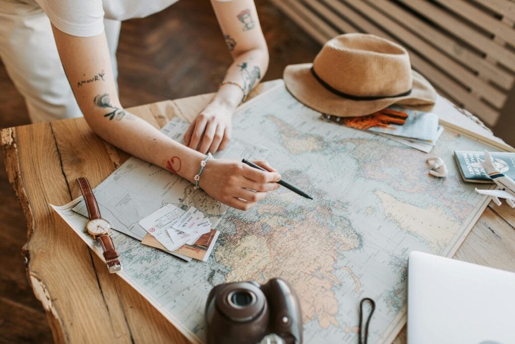 a person sitting at a table with a map and a hat