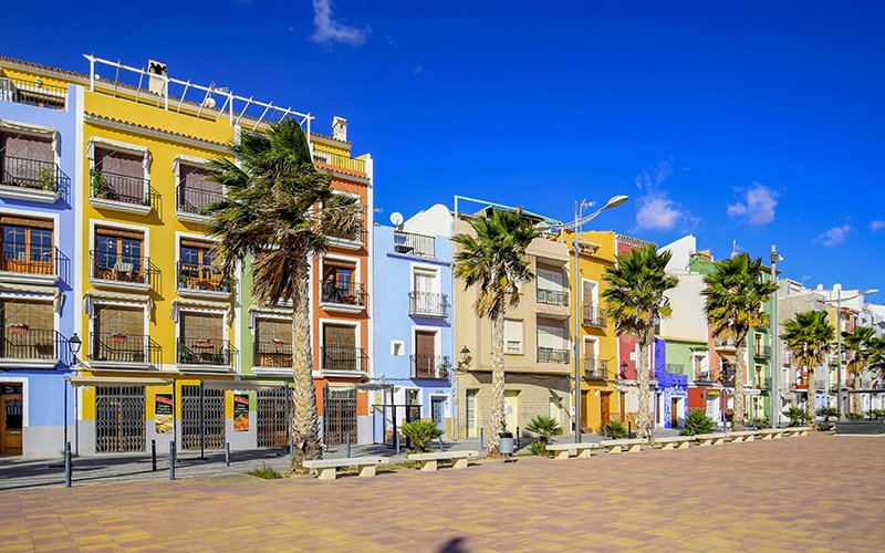 a row of colorful buildings with palm trees