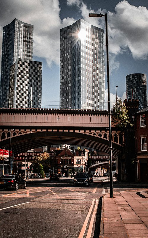 a bridge over a street with cars and buildings